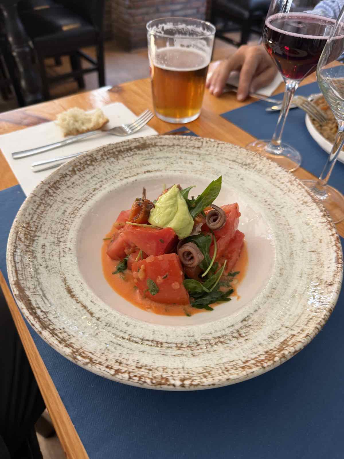 Tartar de atún rojo con aguacate y vino tinto en mesa con mantel azul de Bikainn